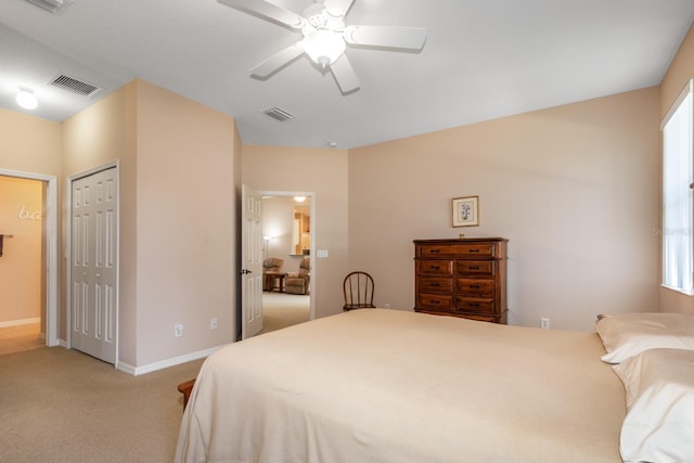 carpeted bedroom featuring ceiling fan, a closet, visible vents, and baseboards