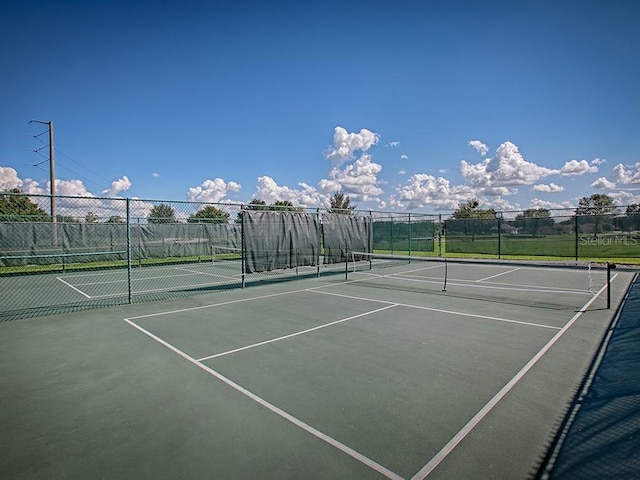 view of tennis court featuring fence