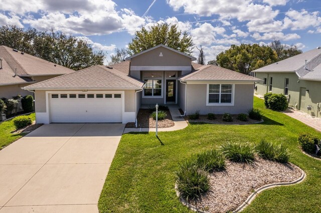 single story home with a front yard, an attached garage, and stucco siding