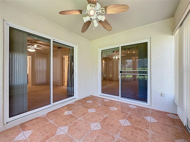 unfurnished sunroom featuring a ceiling fan