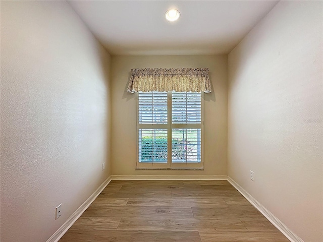 empty room with baseboards and wood finished floors