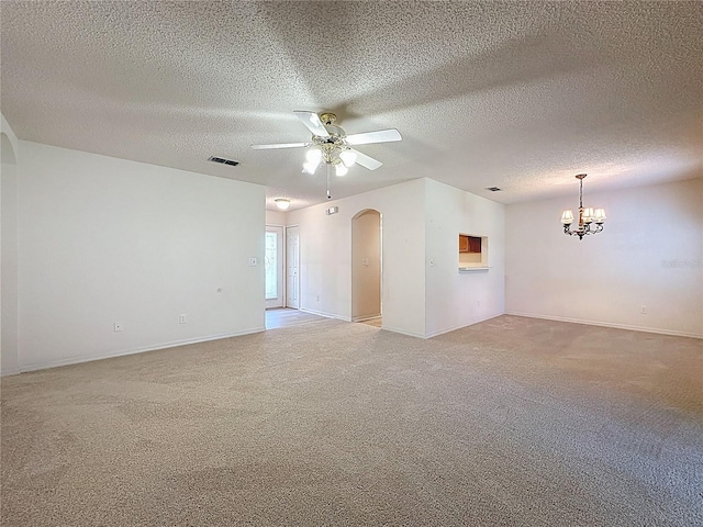 spare room featuring light carpet, visible vents, arched walkways, and ceiling fan with notable chandelier