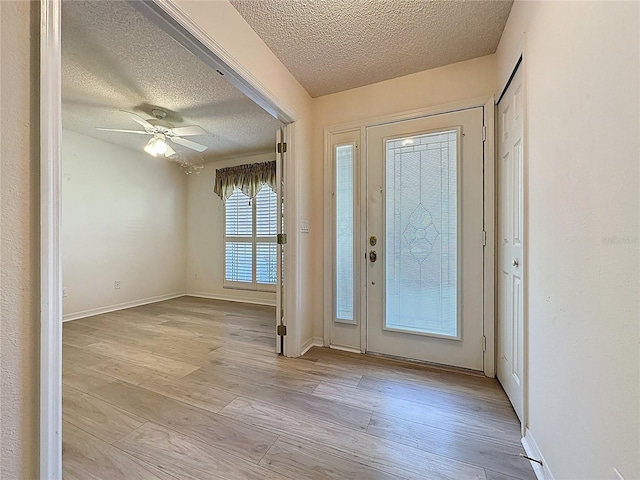 entrance foyer with baseboards, ceiling fan, light wood-style flooring, and a textured ceiling