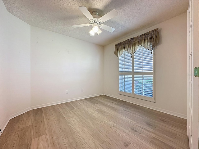 empty room featuring a textured ceiling, baseboards, light wood-style flooring, and a ceiling fan