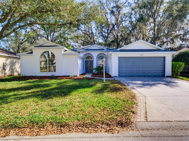 ranch-style home featuring driveway, an attached garage, and a front yard