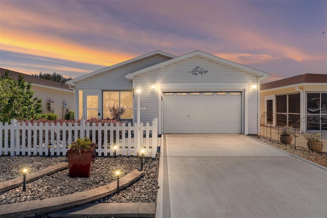 ranch-style house with a garage, concrete driveway, and fence