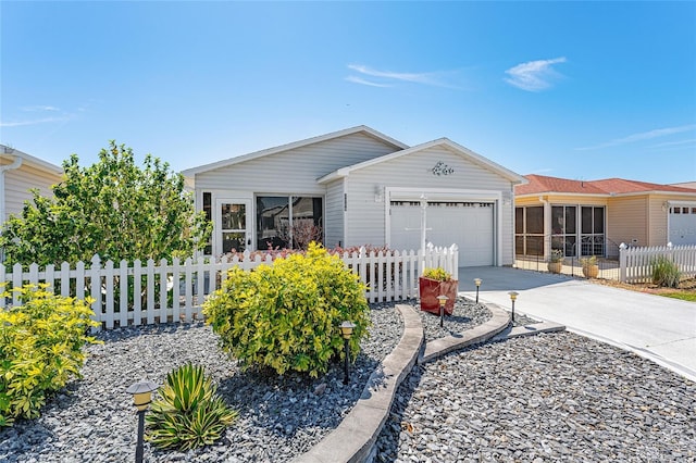 view of front of property with driveway, a fenced front yard, and an attached garage