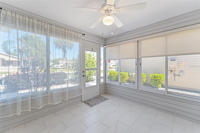 unfurnished sunroom with a ceiling fan