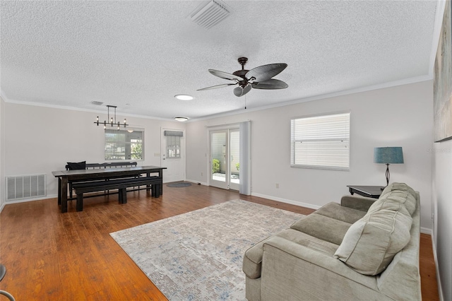 living area with dark wood-style floors, baseboards, visible vents, and crown molding