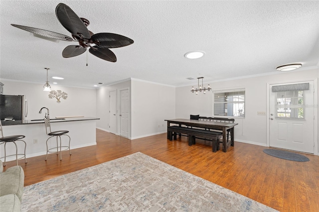 living room with a textured ceiling, ornamental molding, and wood finished floors