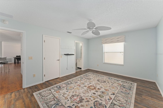 bedroom with visible vents, a textured ceiling, baseboards, and wood finished floors