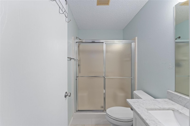 bathroom featuring visible vents, toilet, a stall shower, a textured ceiling, and vanity