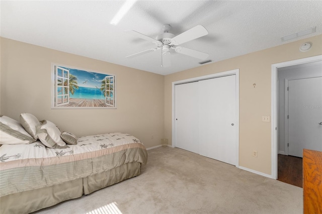 bedroom featuring visible vents, baseboards, a ceiling fan, a closet, and carpet