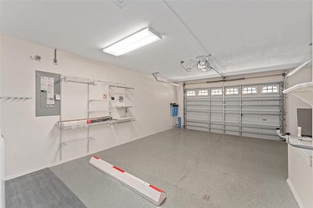 garage featuring electric panel and baseboards