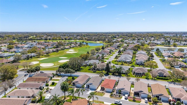 aerial view with golf course view, a water view, and a residential view