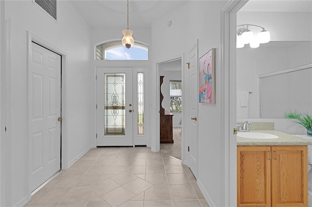 foyer with light tile patterned floors and visible vents