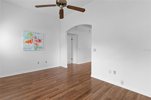 unfurnished room with baseboards, arched walkways, ceiling fan, and wood finished floors