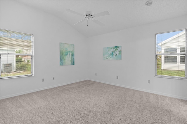 carpeted spare room featuring lofted ceiling, ceiling fan, and baseboards