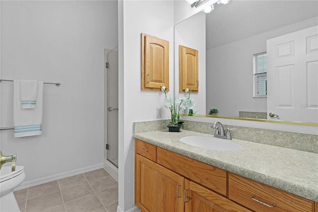 bathroom featuring toilet, vanity, baseboards, a shower stall, and tile patterned floors