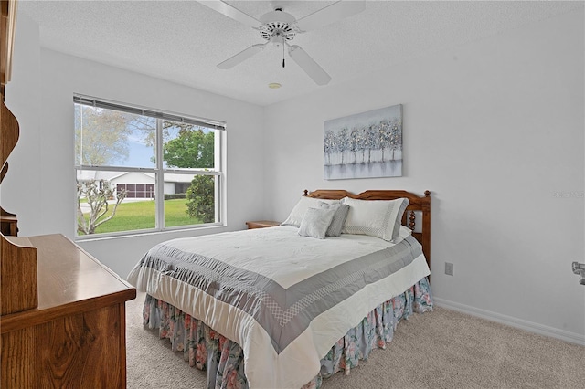 bedroom featuring carpet, ceiling fan, a textured ceiling, and baseboards