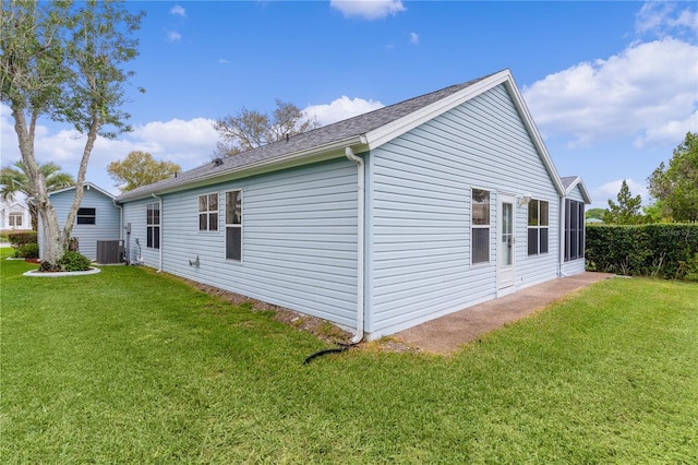 view of side of property featuring a yard and central AC unit