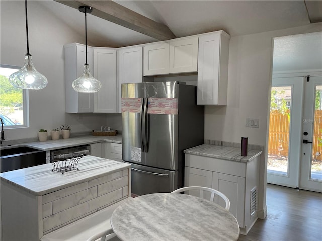 kitchen featuring vaulted ceiling, a sink, freestanding refrigerator, and white cabinets