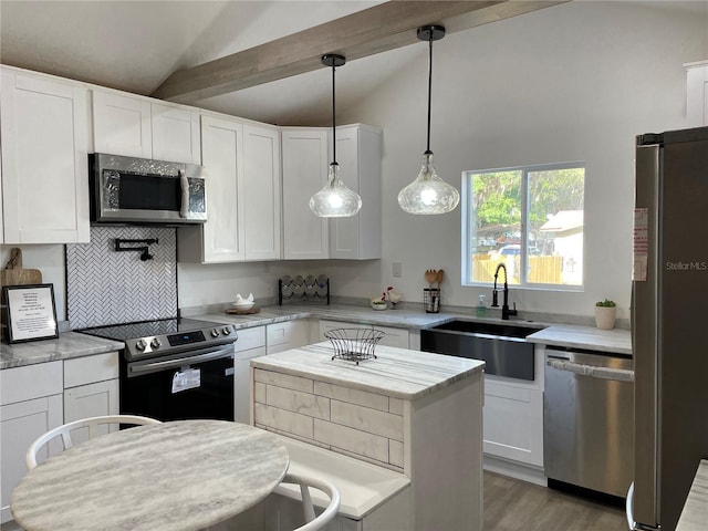 kitchen featuring vaulted ceiling with beams, stainless steel appliances, light wood-style floors, white cabinetry, and a sink