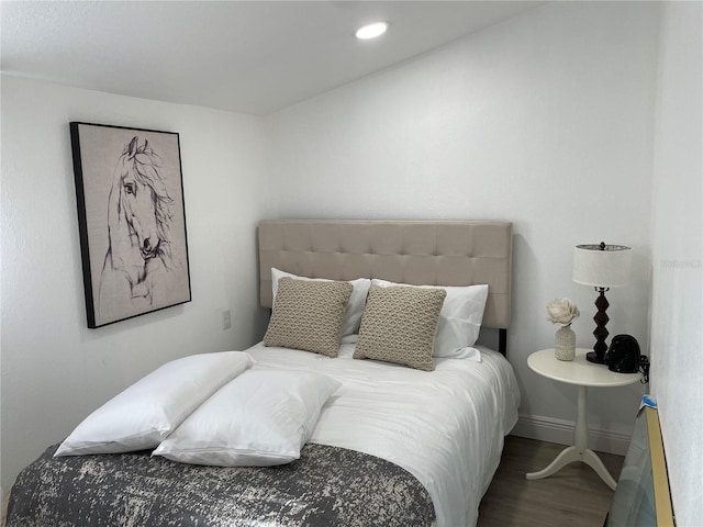 bedroom with baseboards, wood finished floors, and recessed lighting