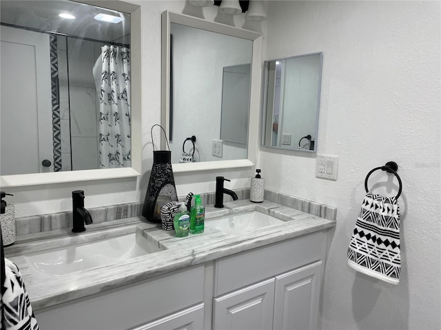 bathroom featuring double vanity, curtained shower, and a sink