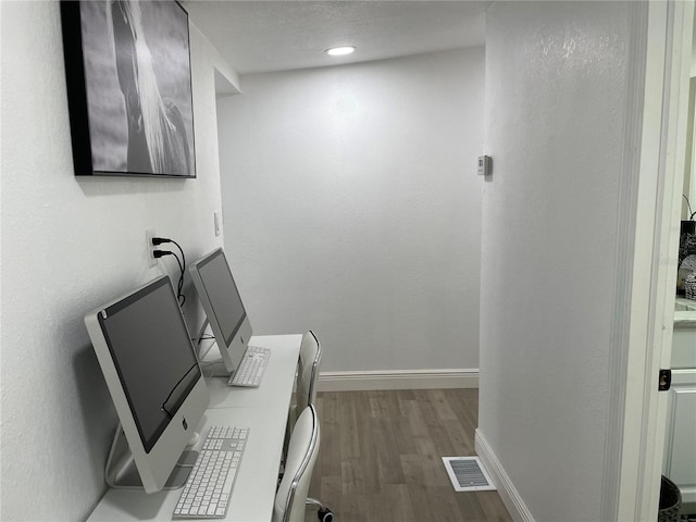 interior space with wood finished floors, visible vents, and baseboards