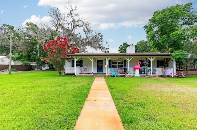 single story home featuring covered porch, a front lawn, and a chimney