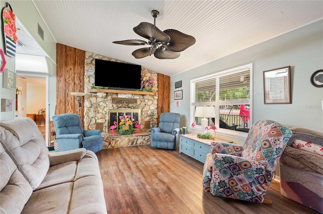 living room with a ceiling fan, a fireplace, visible vents, and wood finished floors