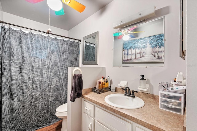 bathroom featuring curtained shower, ceiling fan, vanity, and toilet