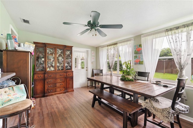 dining room with a ceiling fan, visible vents, and wood finished floors