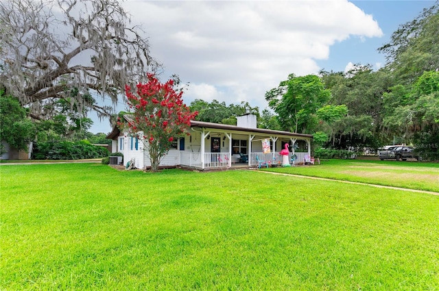 view of front of property with a porch, a front yard, and a chimney