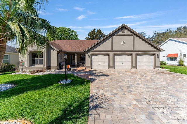 tudor house with a garage, decorative driveway, and stucco siding