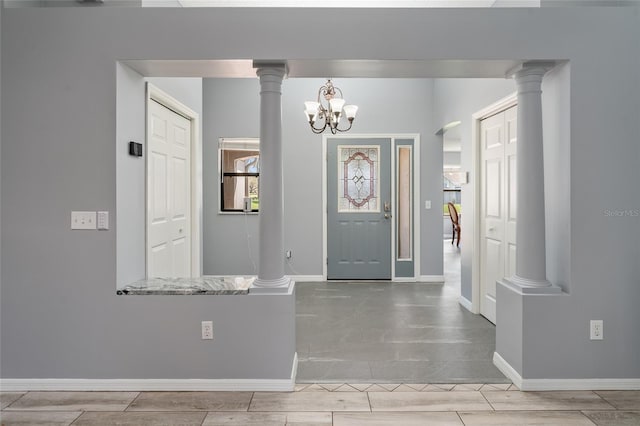 foyer entrance with decorative columns and baseboards