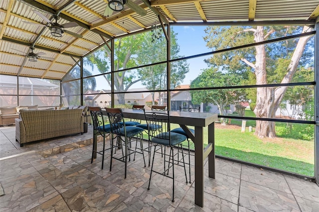 sunroom / solarium featuring ceiling fan and lofted ceiling