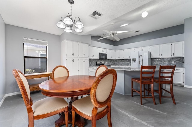 dining room featuring lofted ceiling, visible vents, baseboards, and ceiling fan with notable chandelier