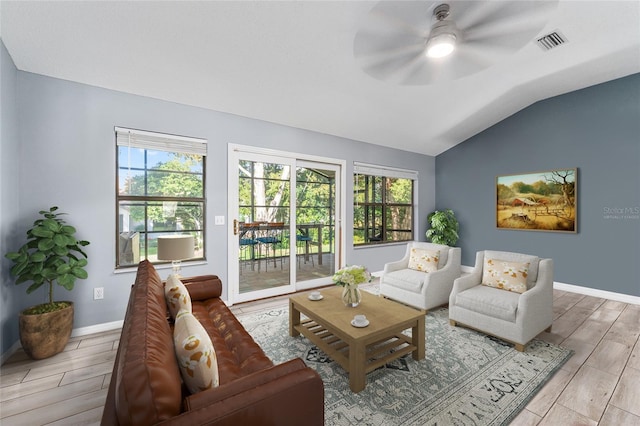 living area featuring vaulted ceiling, wood finish floors, visible vents, and baseboards