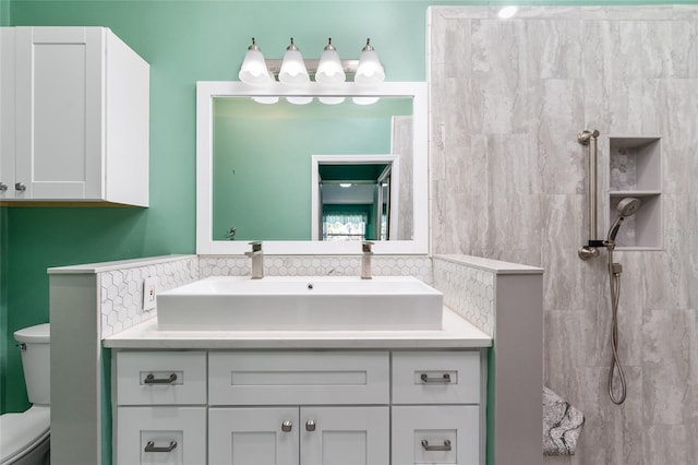 bathroom with toilet, tasteful backsplash, walk in shower, and vanity