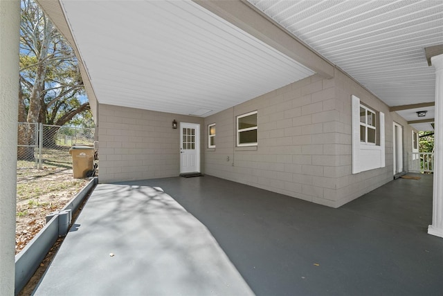 view of patio featuring an attached carport and fence