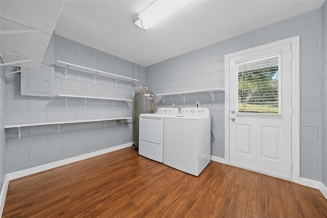 laundry room featuring washing machine and clothes dryer, electric water heater, dark wood-type flooring, baseboards, and laundry area