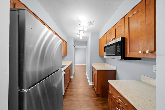 kitchen with visible vents, dark wood-type flooring, appliances with stainless steel finishes, and brown cabinetry