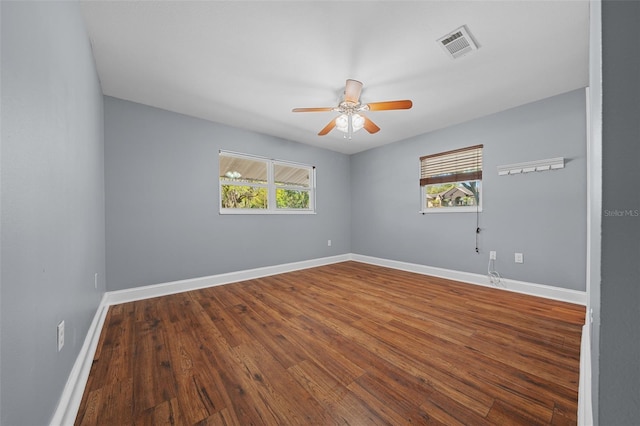 spare room featuring visible vents, baseboards, ceiling fan, and wood finished floors