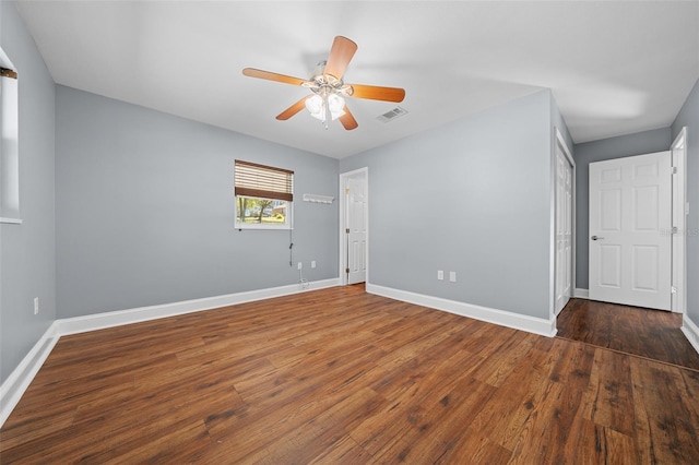 spare room featuring a ceiling fan, wood finished floors, visible vents, and baseboards