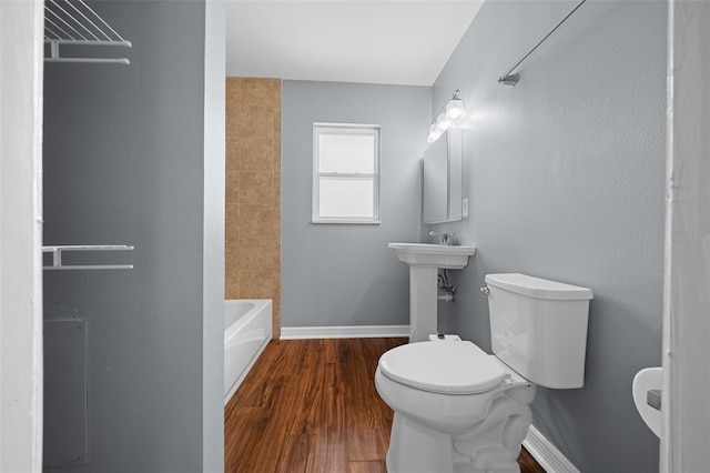 full bath featuring a sink, toilet, baseboards, and wood finished floors