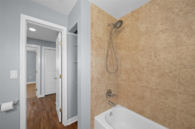 full bathroom featuring bathing tub / shower combination, wood finished floors, and baseboards