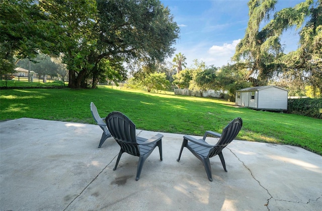 view of patio with an outdoor structure, a storage unit, and fence