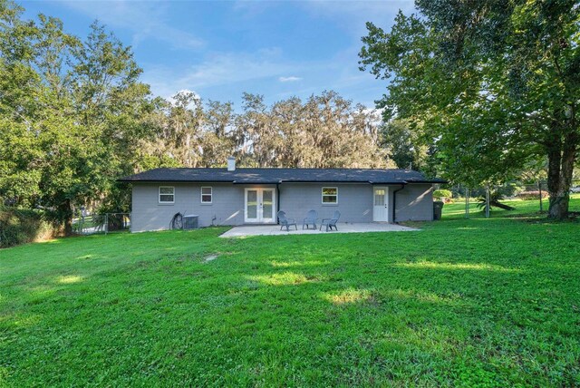 back of house featuring a patio area, a yard, french doors, and central AC